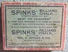 Image: A faded white cardboard box, about 3 by 4 by 1 inches, with a red border and a lot of black text, reading "One dozen pieces SPINKS' BILLIARD CHALK" and various promotional slogans such as "BEST and CHEAPEST", and "USED BY ALL PROFESSIONAL PLAYERS", among other lines, some indistinct.